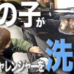女の子がダッジチャレンジャーを磨く。